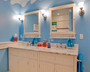 A seaside motif for the kids bathroom.  Pottery Barn cabinets with marble countertops and lots of color make this a great bathroom to share