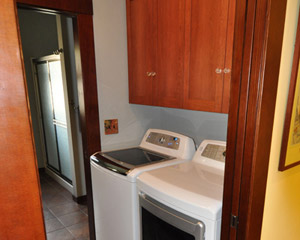 Just off the kitchen is the new laundry room, with washer/dryer on one side, and a convenient storage cabinet and folding counter on the other