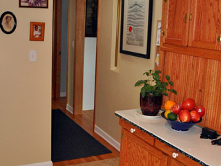 A wall that previously made for an awkward transition from the kitchen to the hall is removed to create better flow to the basement stairs, and a Solatube added for light