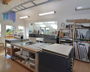 The upper floor studio includes a sink future kitchen area well lit by skylights. Both floors have minimally finished plywood for flooring because they are so likely to have the byproducts of projects end up spilled on them.  That means they're at the right height for future permanent flooring if needed.