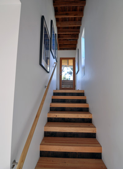 The stairs to the lower level are made from glu-lams, with stained wood risers. The space below hides the water heater.  Each floor has a single Convectaire unit for heat, which keeps the rooms as toasty as they need to be.