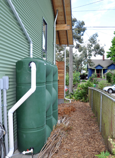 The drainage from the metal roof is directed to a rain garden to the south via above-ground cisterns, allowing nearly all the runoff to be used on site.