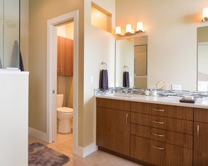 The ensuite master bath is spacious and private, with a separate toilet room, a roomy shower and the same walnut cabinets as the kitchen