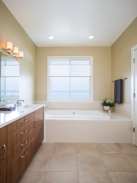 It also features a soaking tub with a view of the water.  Here the counter also waterfalls down from the vanity to the tub deck - peaceful and relaxing