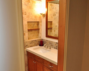 The bath is now a beautiful, uncluttered space to enter, with the soft glow of lighting and warm wood tones