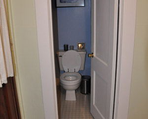 The reconfigured bath includes a pocket door in a new location rather than the old swing door, since space was so tight
