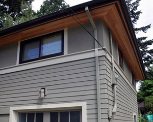The new vented cedar soffits replace the old painted plywood soffits with striking results.   A new garage door, along with insulation and other work in the garage space change the view from the South as well.  Earthquake retrofitting was also done at the basement level wherever there was access