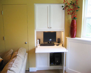 Custom built in place, the cabinet doubles as a computer station.  The door to the left opens up to a mechanical closet, with furnace and hot water heater