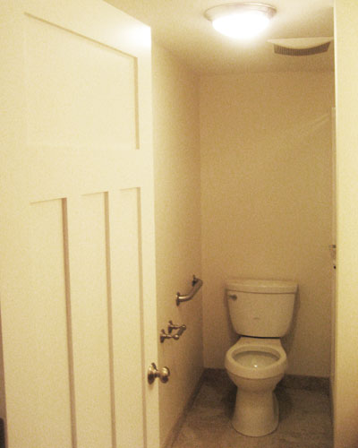 Craftsman style doors carry some of the main floor finishes into the basement area, including this basement bathroom remodel