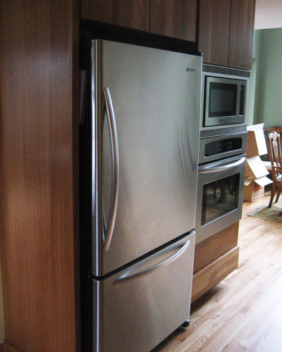 The fridge and ovens are tucked into a hall leading to the new dining room