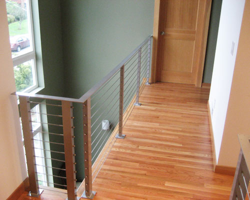 The upper hall doubles as a lookout onto the expansive 2-storm atrium windows and down into the dining room