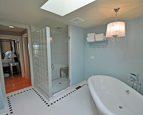 Where the old bathroom stood is a spacious master closet, a toilet room, and a new shower with a ceiling-mounted and a hand-held shower head. Oversized hexagonal tile defines the room. Recommended remodelers Seattle