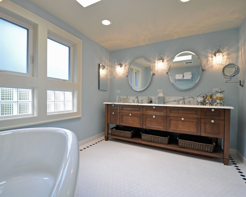 The custom vanity is built from quarter-sawn oak, with stain to match an antique table elsewhere in the home.  The baskets below provide extra storage, while the doors and drawers conceal other toiletries