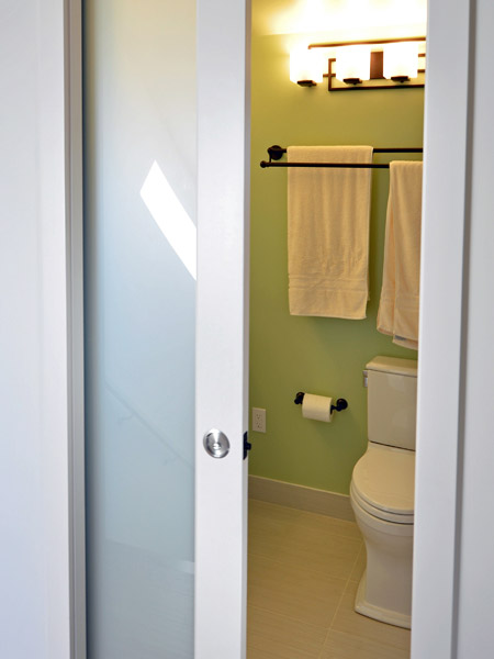 A pocket door with frosted glass is the entry, making it possible to have natural light in the stairwell even if the door is closed