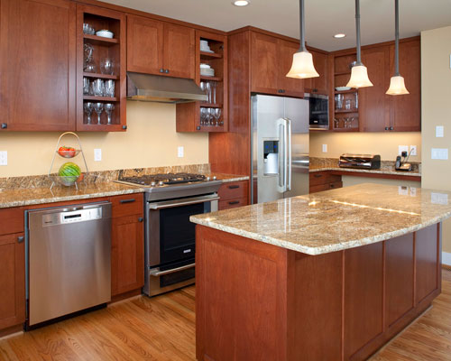 Custom cherry cabinets from Baywood Cabinets provide a colorful counterpoint to the oak flooring.  A dedicated kitchen desk area keeps everyone in the family organized.  And Golden Oasis granite counters reflect the blue skies and blue waters of Lake Washington outside