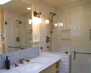 The small space is maximized by using mirrors, windows and a frameless glass shower enclosure