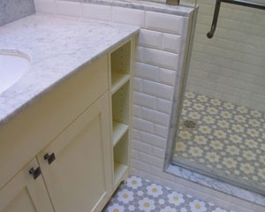 The old-fashioned tile compliments the Carrera marble counters'pillow-style subway tile and flowery hexagon floor tile, hexagon tile bathroom