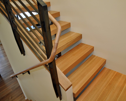 The treads are solid laminated oak, and the landing is from the same material, in 3 sections.  A cap in oak on the center wall completes the look
