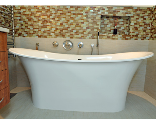 Where a dated vanity once stood there is now an elegant Victoria + Albert soaking tub with a niche and hand-held faucet