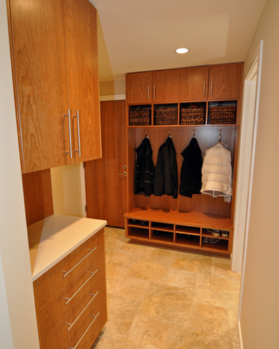 Outside the powder bath, a new mudroom cabinet is both beautiful and functional, with cubbies built to fit the baskets.  The door was originally not slated for replacement, but then added to keep materials and wood tones consistent