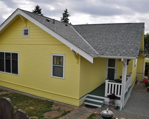The finished addition includes a covered porch and copies the details of the existing home - trim, windows and knee posts