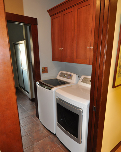 Just off the kitchen is the new laundry room, with washer/dryer on one side, and a convenient storage cabinet and folding counter on the other