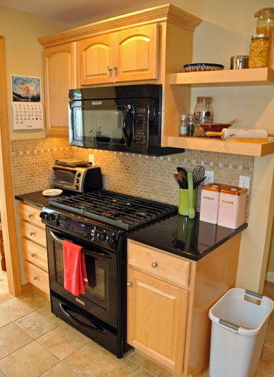 The entire stove area is relocated to where the dining table was, and a few added cabinets finish out the area