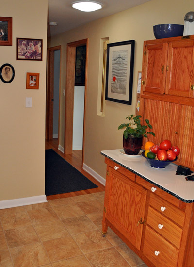 A wall that previously made for an awkward transition from the kitchen to the hall is removed to create better flow to the basement stairs, and a Solatube added for light