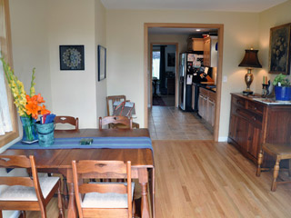 The new wood flooring in the dining room is installed at the same level as the kitchen tile, with a new cased opening between the rooms.  Lots of windows--including ones removed from the new door opening and reinstalled--make the dining room light and bright