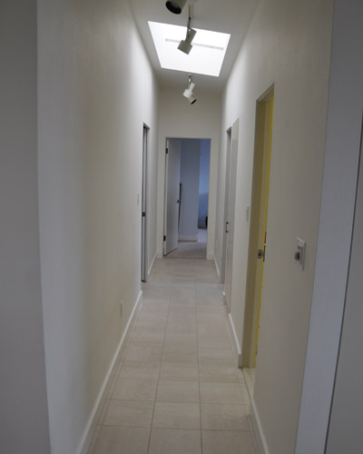 The hall started out all white, and the solution to that is some color.  The owners decided to trade out the doors for natural cherry, including a linen cabinet door