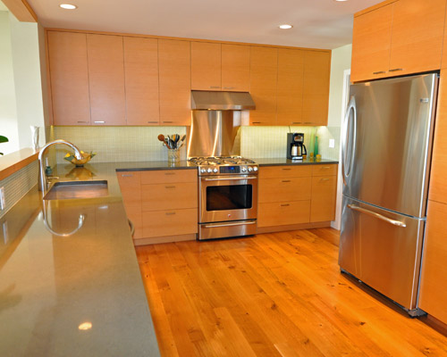 The revised kitchen deletes that cooking area, and has custom horizontal grain fir cabinets and concrete countertops.  The fir continues in a cap at the half wall that divides the kitchen from the living room