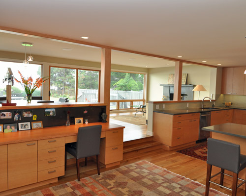 The open concept layout has the kitchen extending south to a desk area with the same fir cabinets and a VG fir desktop.  The backsplash here is blackened steel and functions as a magnet board as well