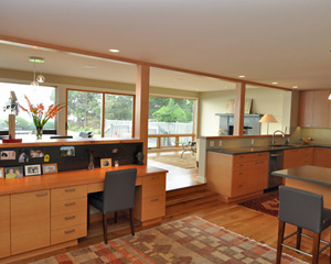 The open concept layout has the kitchen extending south to a desk area with the same fir cabinets and a VG fir desktop.  The backsplash here is blackened steel and functions as a magnet board as well