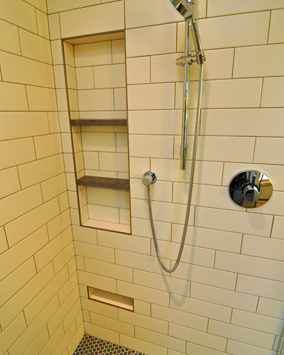 The large niche has plenty of room for shampoo and soap, with limestone shelves  dividing the space.  A small niche at the very bottom makes shaving legs easy. Seattle tile bath
