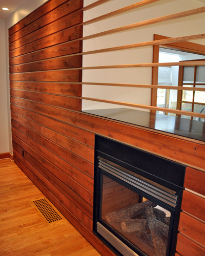 The natural wood is inset into a sheetrock frame to the left, and the VG fir extends through the fireplace opening, creating a clear delineation between the dining and living areas without blocking light