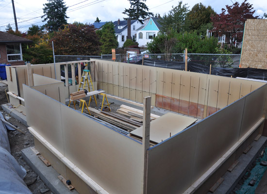 By keeping part of the main level below grade, the new studio takes advantage of two stories of height without creating a building that towers over the main house downslope. It also minimizes the impact on neighbors' views.