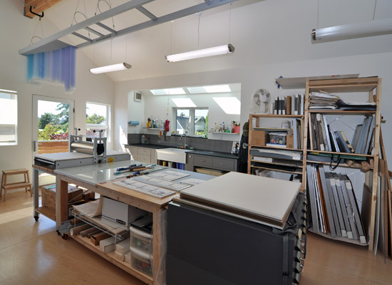 The upper floor studio includes a sink future kitchen area well lit by skylights. Both floors have minimally finished plywood for flooring because they are so likely to have the byproducts of projects end up spilled on them.  That means they're at the right height for future permanent flooring if needed.