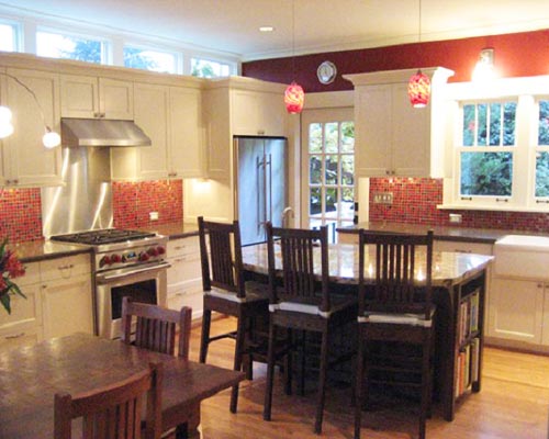 Custom white cabinets are juxtaposed against Disco Inferno mosaic glass tile.  Note the clerestory windows to the left that bring in light above the cabinets