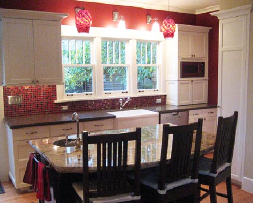 Lindal windows overlook the sink area, which includes an iron farm sink and Caesarstone countertops.  Note the hand-blown pendant lights from Blowing Sands in Ballard