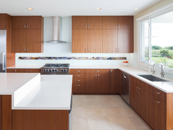 The kitchen features custom quartered walnut cabinets with lush wood tones and ample storage opportunities