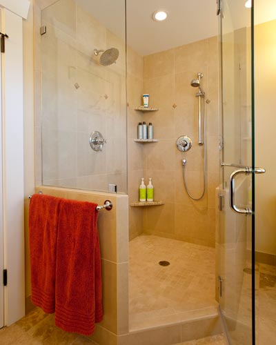 Sheer luxury in the master shower:  two shower heads and a frameless glass enclosure up to beautifully tiled walls