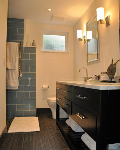 The vanity is from Restoration Hardware, with a Carerra marble countertop and backsplash.  Recessed medicine cabinets provide storage, along with the shelving below, which is an ideal location for towels.  The window at the end is an awning with reed glass, providing a little extra ventilation.  Note the shape of the shower entry... it follows the lines of the masonry fireplace that it conceals.