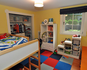An ideal basement bedroom:  bright colors, functional space, and a big egress window.   As in the master bedroom, this is a hopper window that opens into the room.   The closet has doors, but the clients opted to keep them off for now for easy access to items stored there. Kids remodeling Seattle