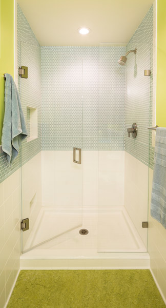 Marmoleum floors and a tile shower with cast iron pan, and Avonite counters over a custom cabinet make the most of the space, which is brightened by vibrant colors