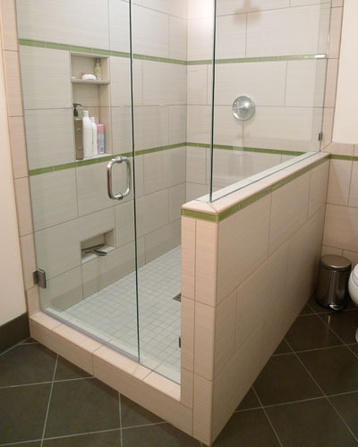 With a commanding spot in the bathroom and glass half walls to let the light in, the shower is both spacious and beautiful.  Niches on the wall provide space for shampoo and the one at the very bottom holds the glass squeegee, and is a convenient leg up while shaving, Seattle shower niche
