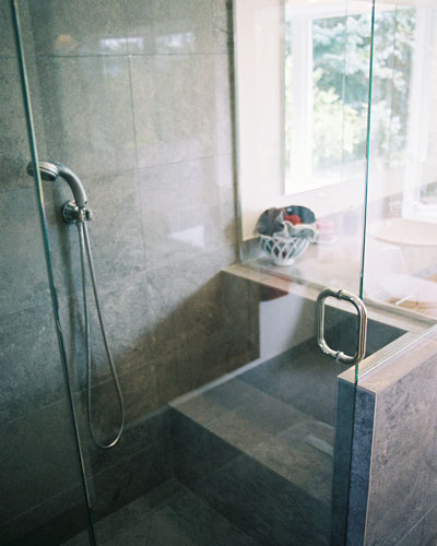 The shower has integrated, tiled seating at one end.  The glass shower surround helps make this bathroom feel bigger than it is.   This was important because the previous shower was walled in on three sides