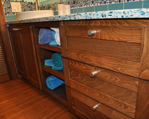 The new vanity is both beautiful and functional, with storage shelves in the middle.  Alder wood matches the existing trim in the master suite, with a stain chosen to match