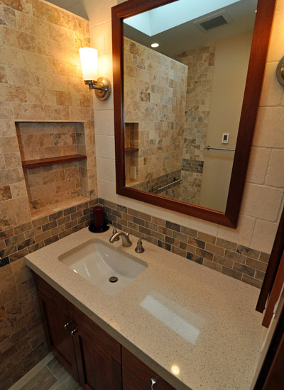 There is also a small niche to the left of the sink, with a mahogany sill in the middle.  The tile from the shower wraps all the way around and then makes a change to a lighter tile at the vanity