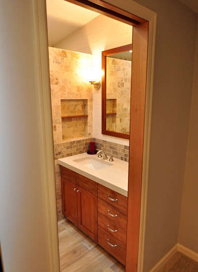 The bath is now a beautiful, uncluttered space to enter, with the soft glow of lighting and warm wood tones