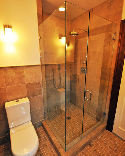 The tile continues at the shower, with slab sea grass used at the threshold.  The relatively small space still feels quite open thanks to the full glass shower surround